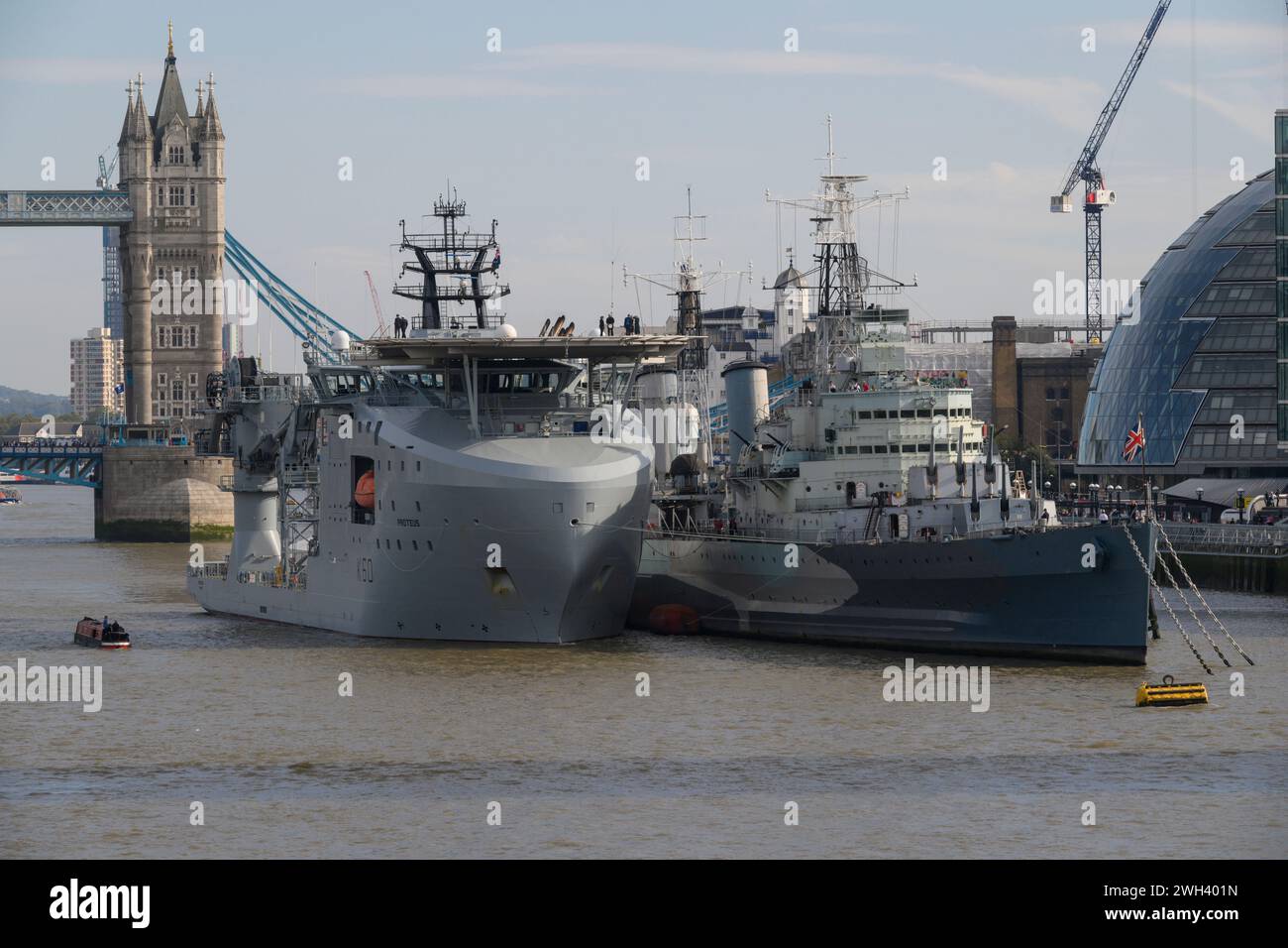 The RFA Proteus, a ship of the Royal Fleet Auxiliary, moored alongside HMS Belfast, a WWII cruiser. The River Thames, London, UK.  10 Oct 2023 Stock Photo