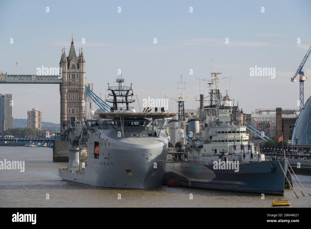 The RFA Proteus, a ship of the Royal Fleet Auxiliary, moored alongside HMS Belfast, a WWII cruiser. The River Thames, London, UK.  10 Oct 2023 Stock Photo