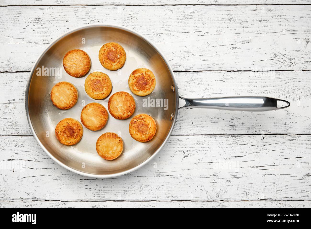 Cottage cheese pancakes. Syrniki in a frying pan. Cheesecakes, top view, flat lay. Stock Photo