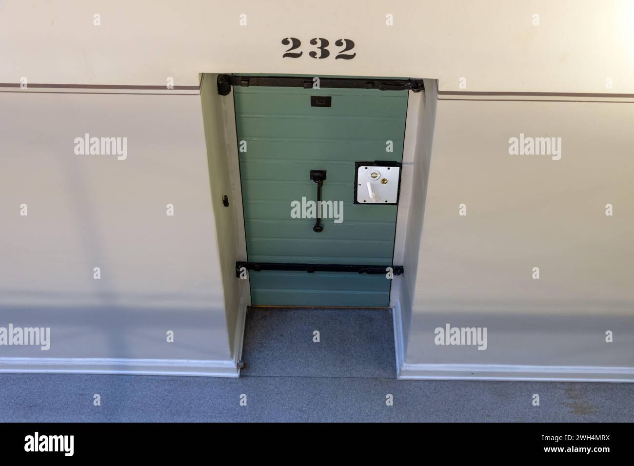 A cell door in a prison corridor Stock Photo