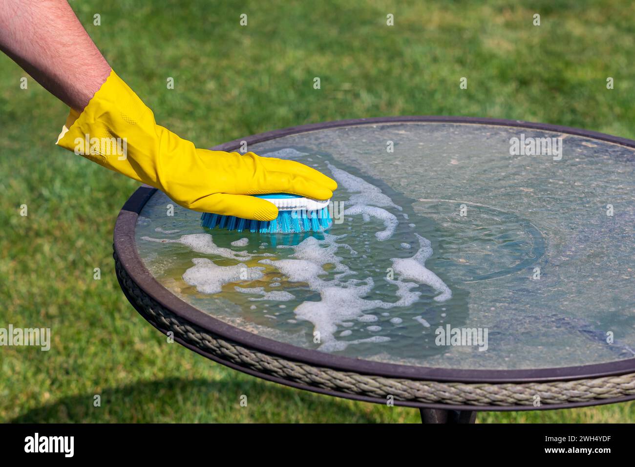 Cleaning patio furniture by hand with brush. Spring cleaning, household