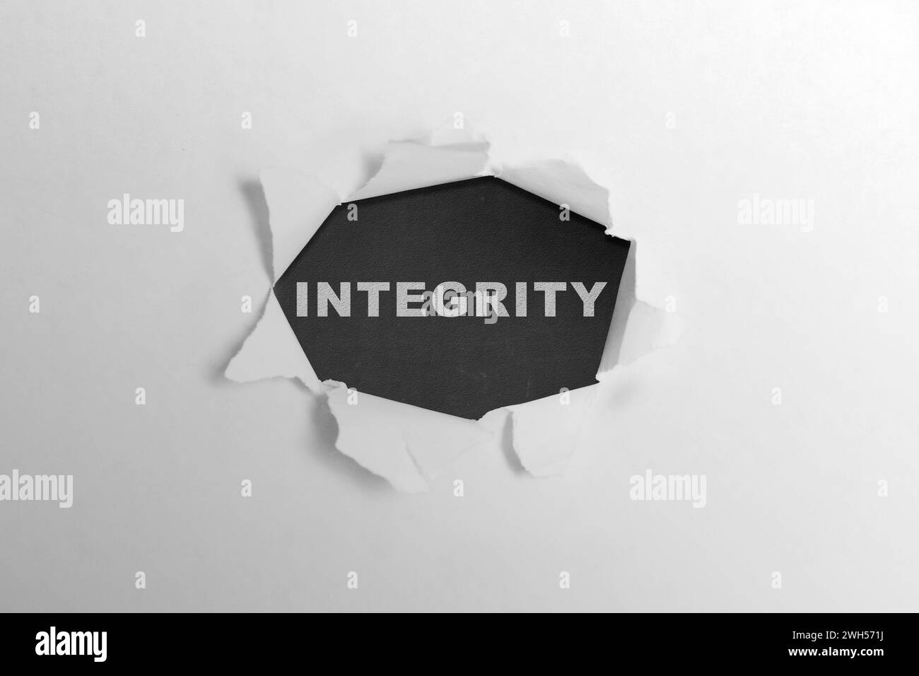 Ripped paper with integrity text on a black background. Reputation integrity concept Stock Photo