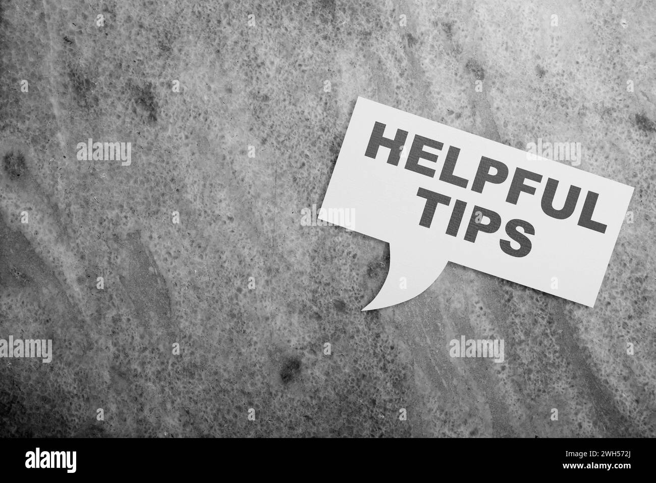 Bubble speech with 'Helpful tips' text on a black background. Tips and advice concept Stock Photo