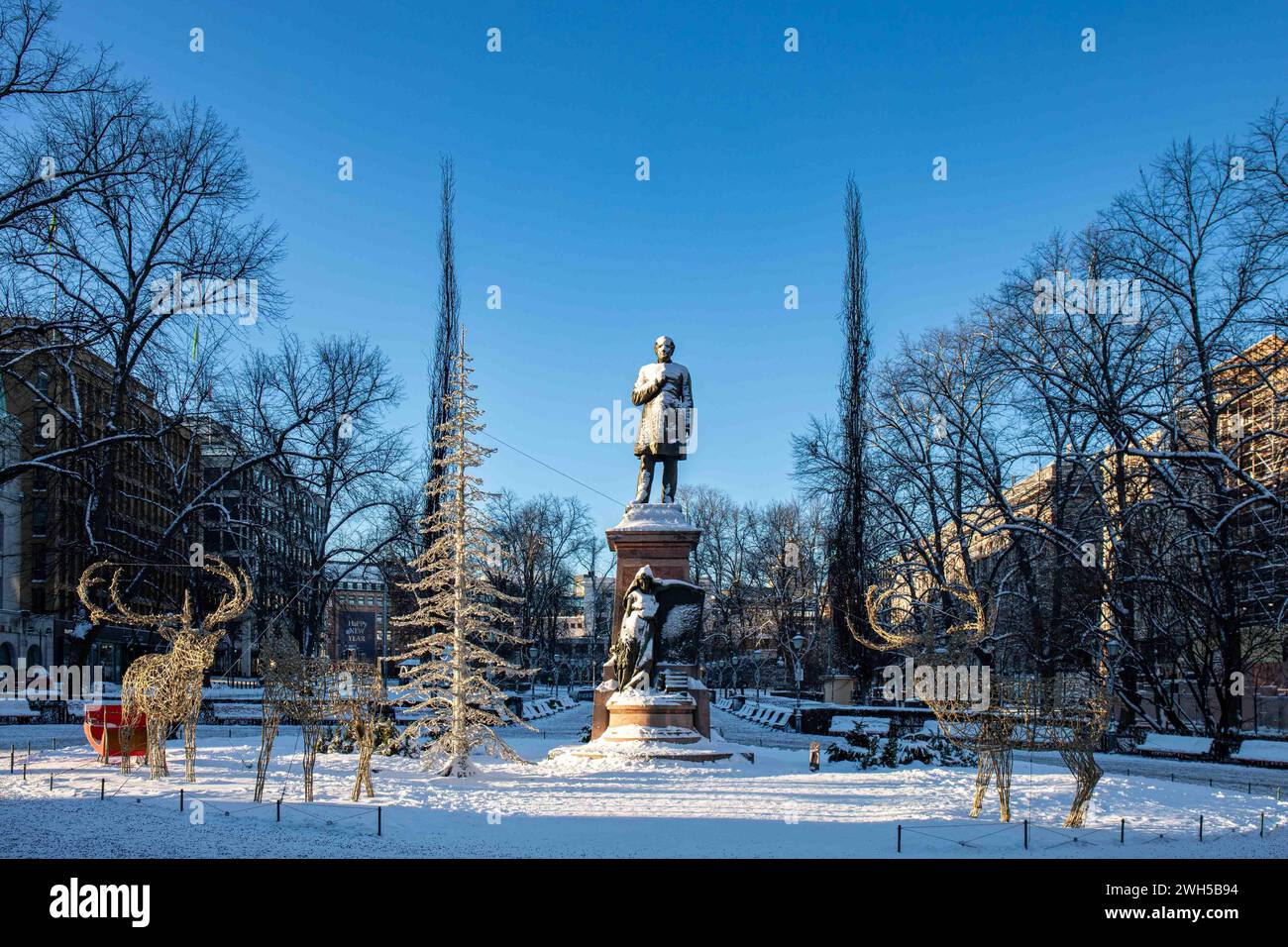 Snow covered statue of Johan Ludvig Runeberg against clear blue sky in Esplanadi Park in Helsinki, Finland Stock Photo