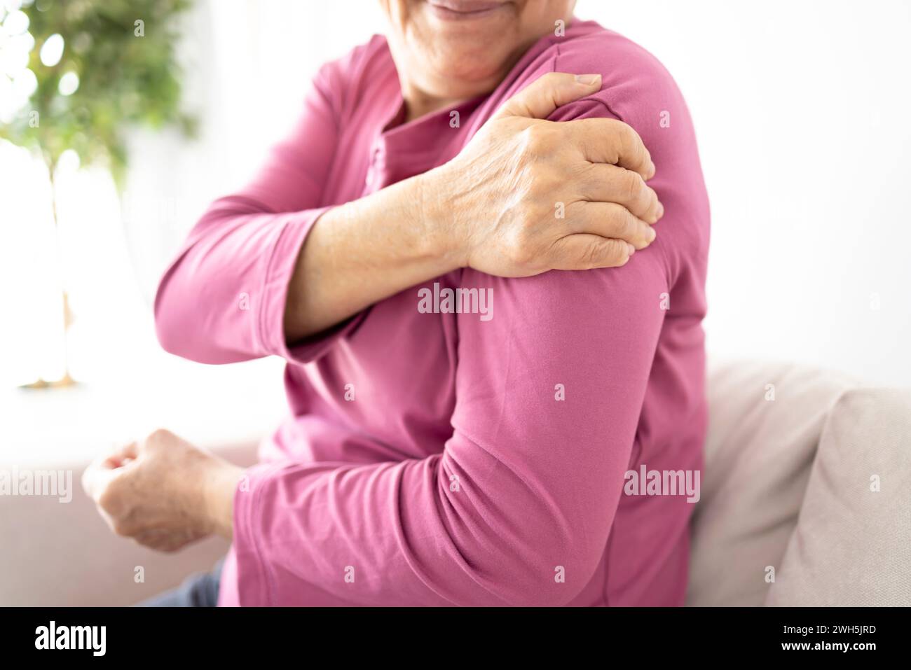 Senior woman suffers from shoulder joint pain, shoulder stiffness or osteoporosis Stock Photo