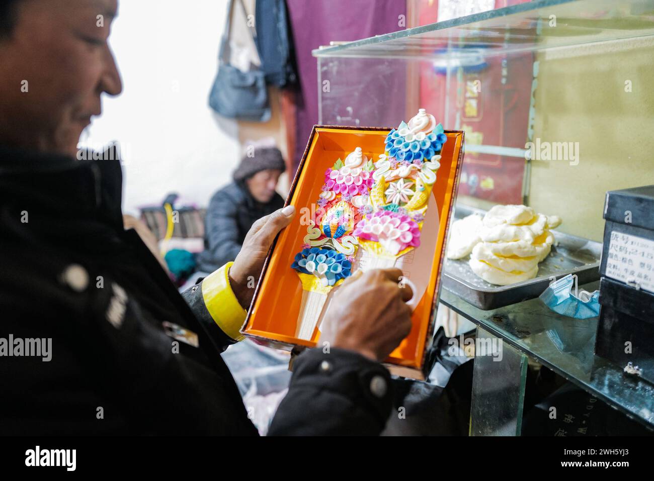 Lhasa, China's Xizang Autonomous Region. 7th Feb, 2024. A craftsman puts butter sculptures into a box in Lhasa, southwest China's Xizang Autonomous Region, Feb. 7, 2024. The Tibetan New Year coincides with the Lunar New Year, or the Spring Festival, which falls on Feb. 10 this year. As the New Year is approaching, butter sculptures handmade by local craftsmen sell quite well in Xizang. Credit: Sun Ruibo/Xinhua/Alamy Live News Stock Photo