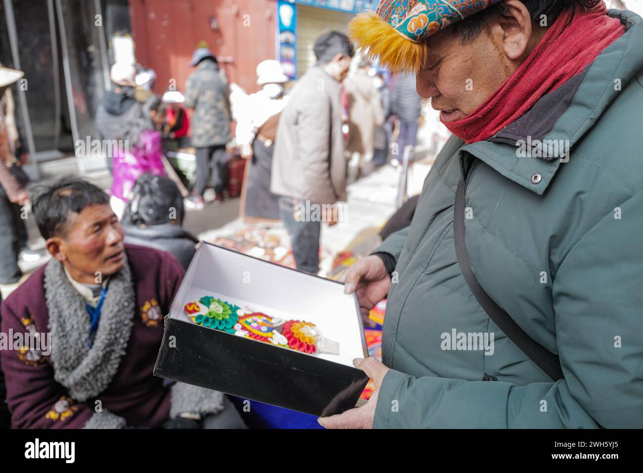 Lhasa, China's Xizang Autonomous Region. 7th Feb, 2024. A customer selects butter sculptures in Lhasa, southwest China's Xizang Autonomous Region, Feb. 7, 2024. The Tibetan New Year coincides with the Lunar New Year, or the Spring Festival, which falls on Feb. 10 this year. As the New Year is approaching, butter sculptures handmade by local craftsmen sell quite well in Xizang. Credit: Sun Ruibo/Xinhua/Alamy Live News Stock Photo
