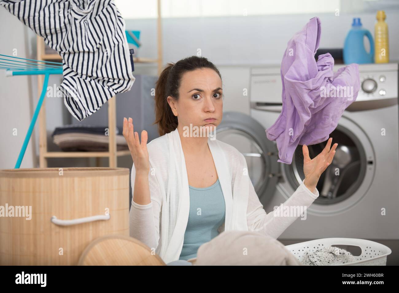 young woman looking at clothes after washing Stock Photo