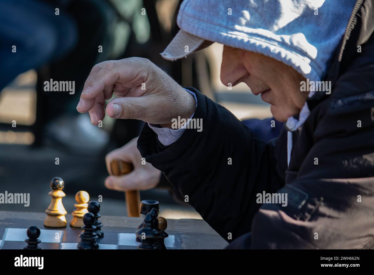 Elderly retired persons pasionatelly playing chess figurines in public park in Belgrade, nice sunny day Stock Photo