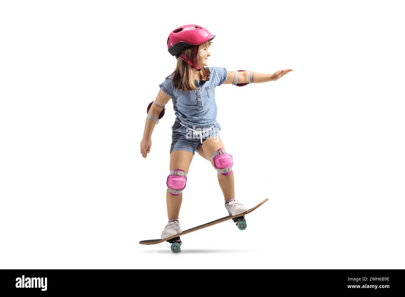 Little girl riding a skateboard with helmet, knee and elbow pads