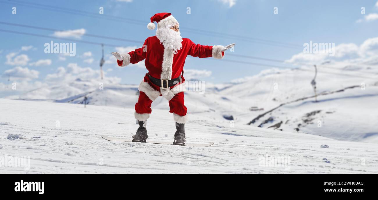 Santa claus at a ski resort riding a snowboard Stock Photo