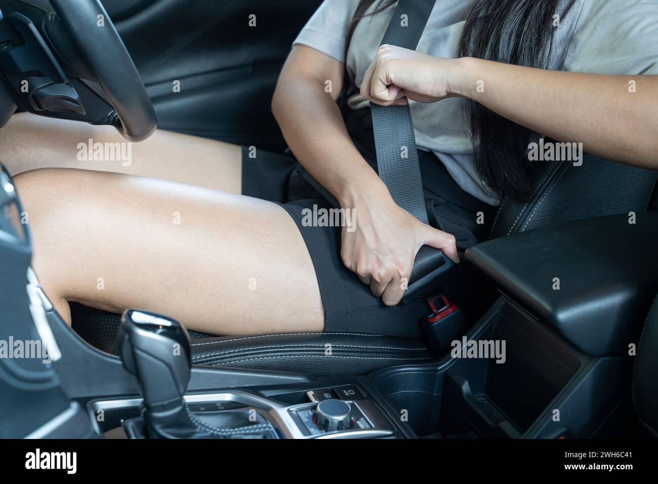 Close up of hand woman pulling seat belt in her car; Car safety concept. Stock Photo