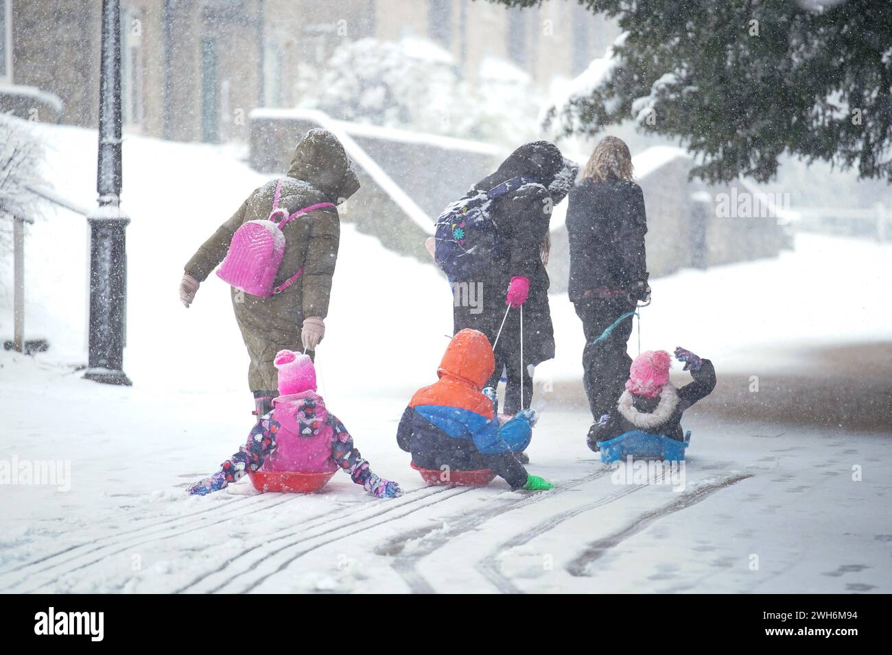 Children are pulled on sleds in Buxton, Peak District. Up to 25cm of snow is forecast in parts of England and Wales, as the Met Office issued weather alerts and warned of disruption to travel. Picture date: Thursday February 8, 2024. Stock Photo
