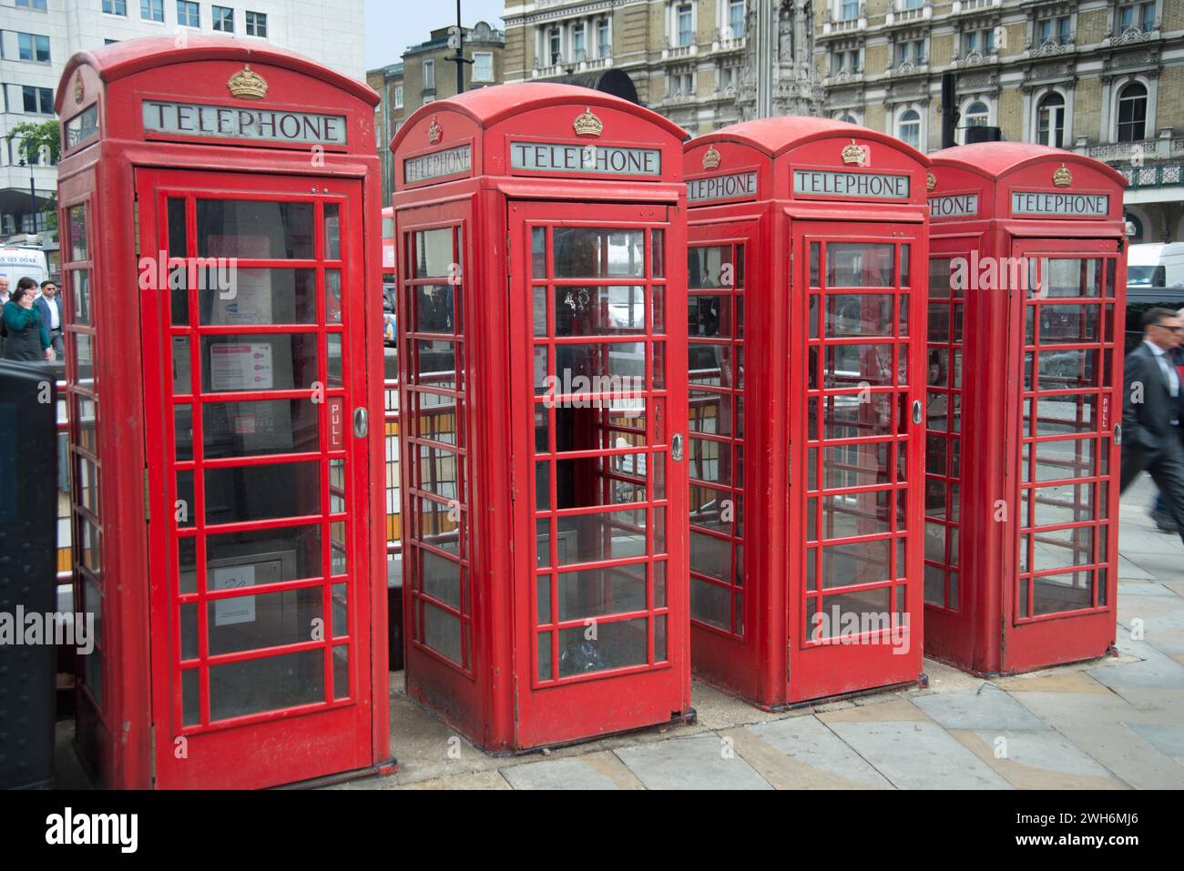 A row of four red telephone boxes on The Strand at Charing Cross, London, England Stock Photo