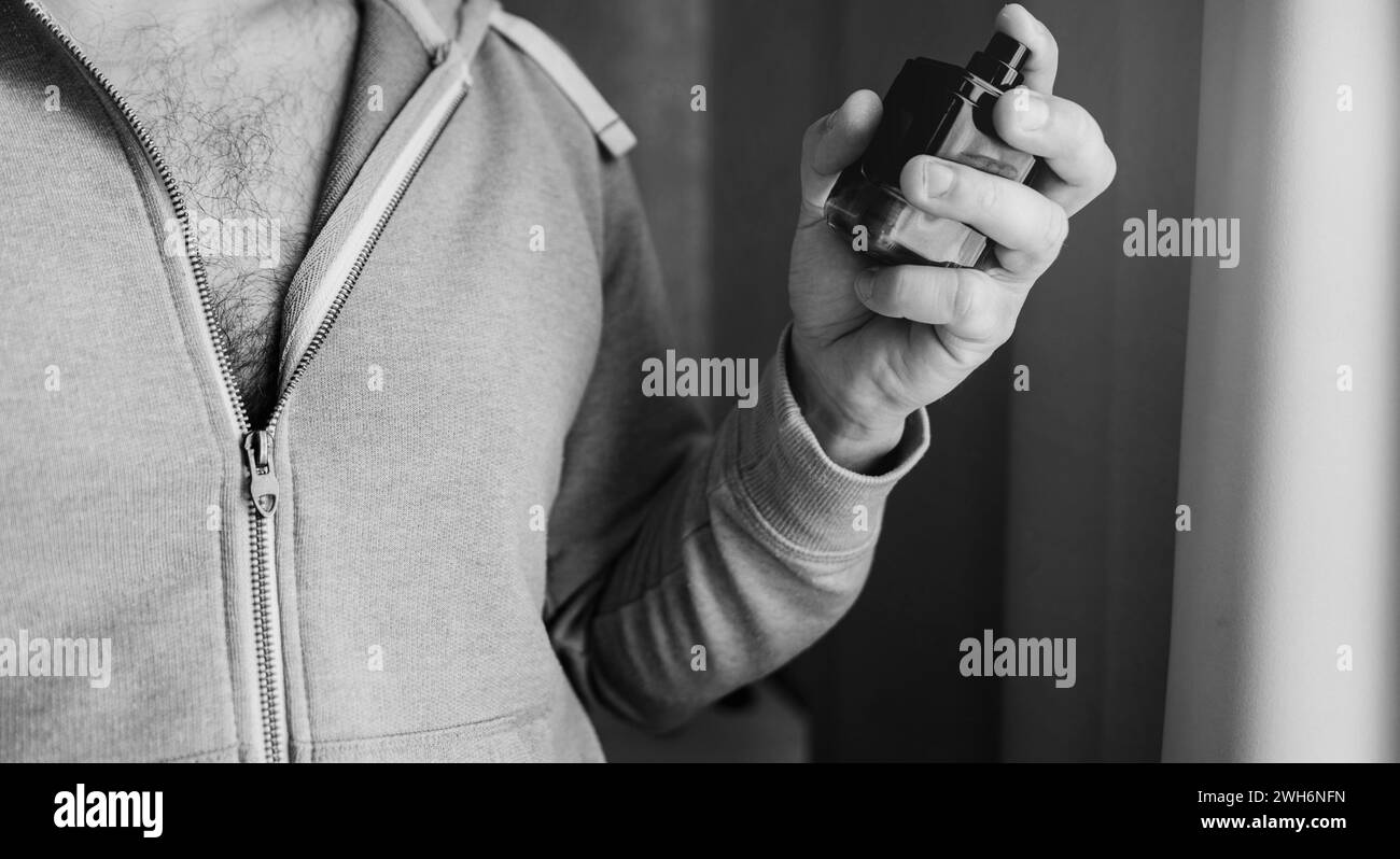 Man with a bottle of perfume. self-grooming guy Stock Photo