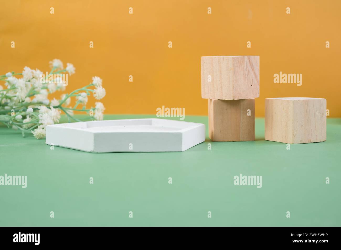 Wooden cube podium on yellow background. Display case for cosmetic products. Product advertising. Layout style display. Stock Photo