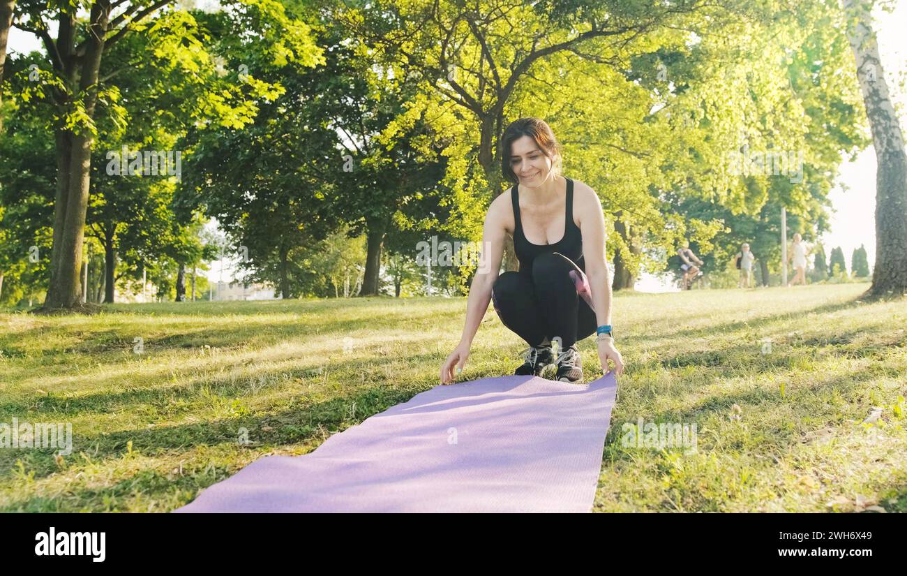 Fitness girl with a map for yoga preparing to practice yoga, outdoor recreation and workout exercises Stock Photo