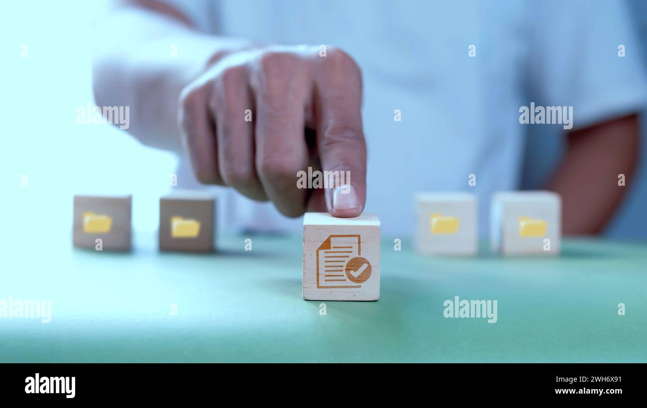 Businessman pushing wooden cube with documents icon. Search and manage document database files. Document management system concept Stock Photo