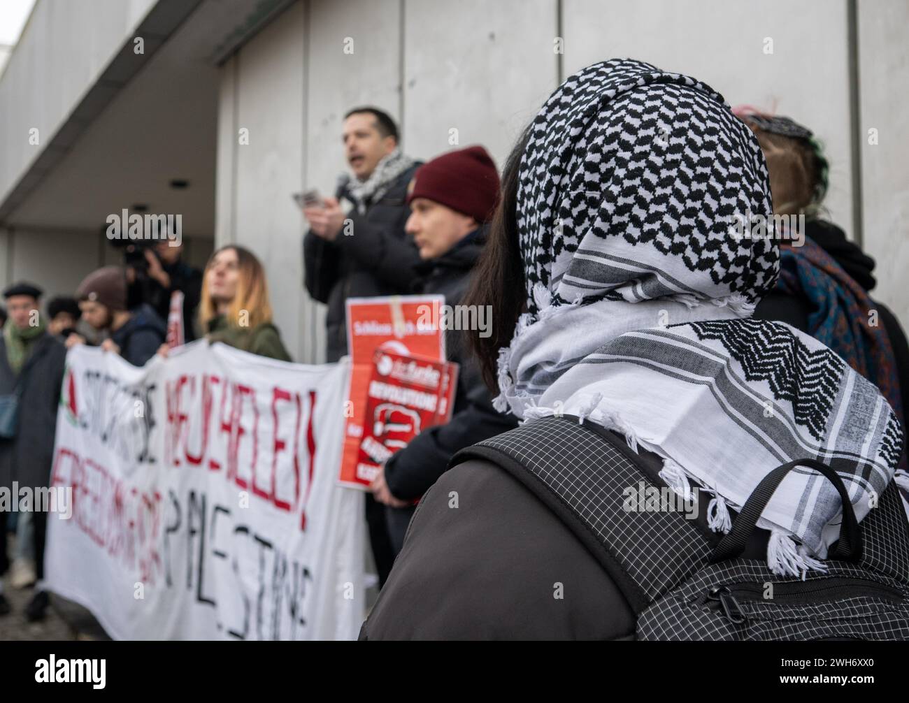 Berlin, Germany. 08th Feb, 2024. A participant in the pro-Palestinian rally under the motto 'Solidarity with Palestine' in front of Mensa II at Freie Universität (FU) wears a Palestinian scarf on her head. The university has been criticized from several sides after a Jewish student was beaten and kicked by his pro-Palestinian fellow student at the weekend. Credit: Monika Skolimowska/dpa/Alamy Live News Stock Photo