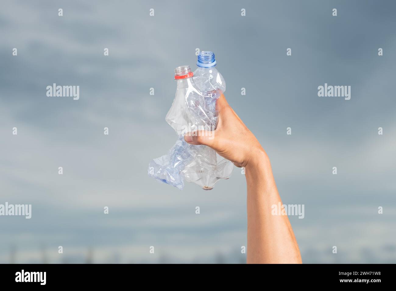 Crumpled waste plastic bottles in male hands. Recyclable trash Stock Photo