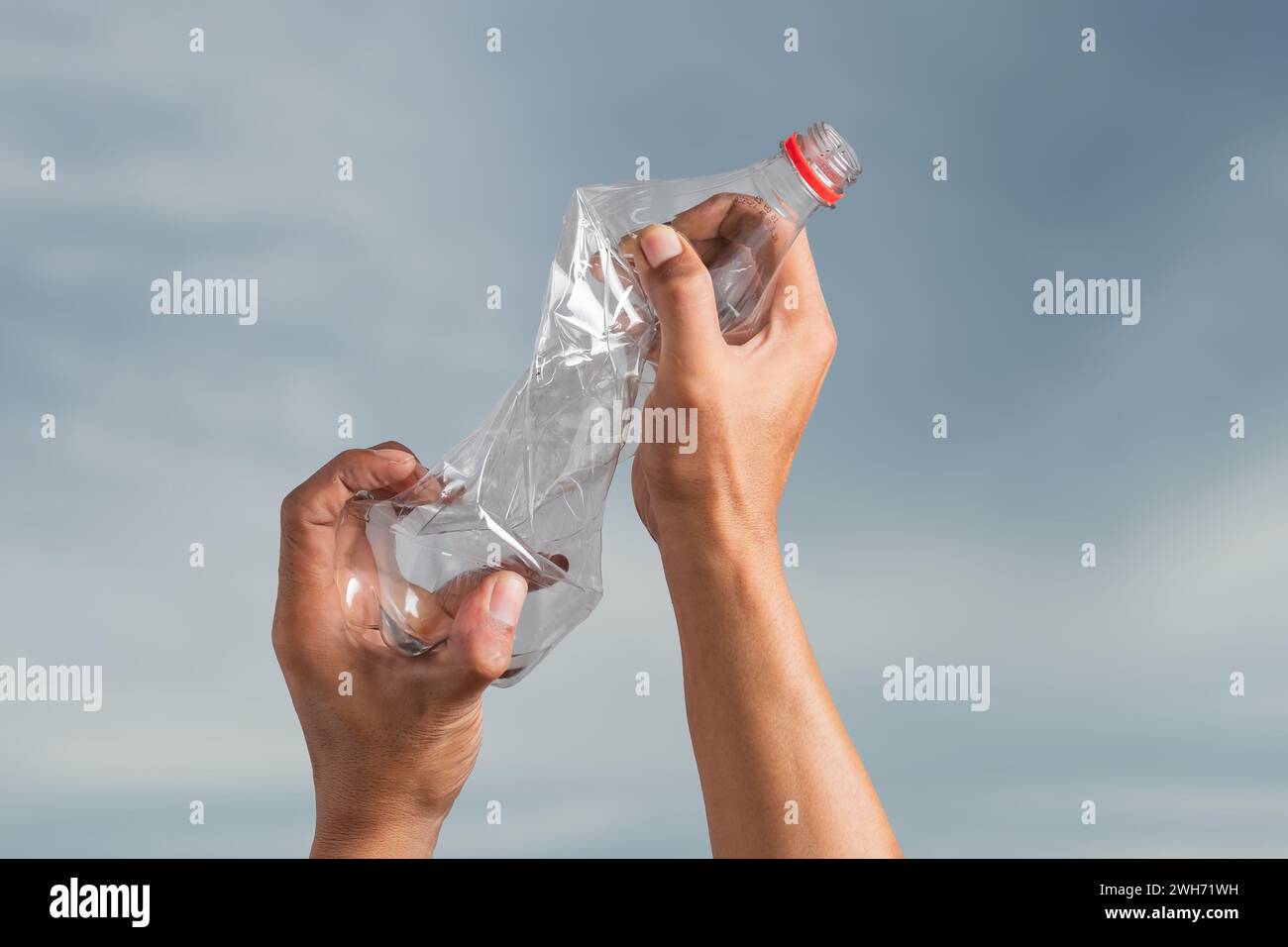 Crumpled waste plastic bottles in male hands. Recyclable trash Stock Photo