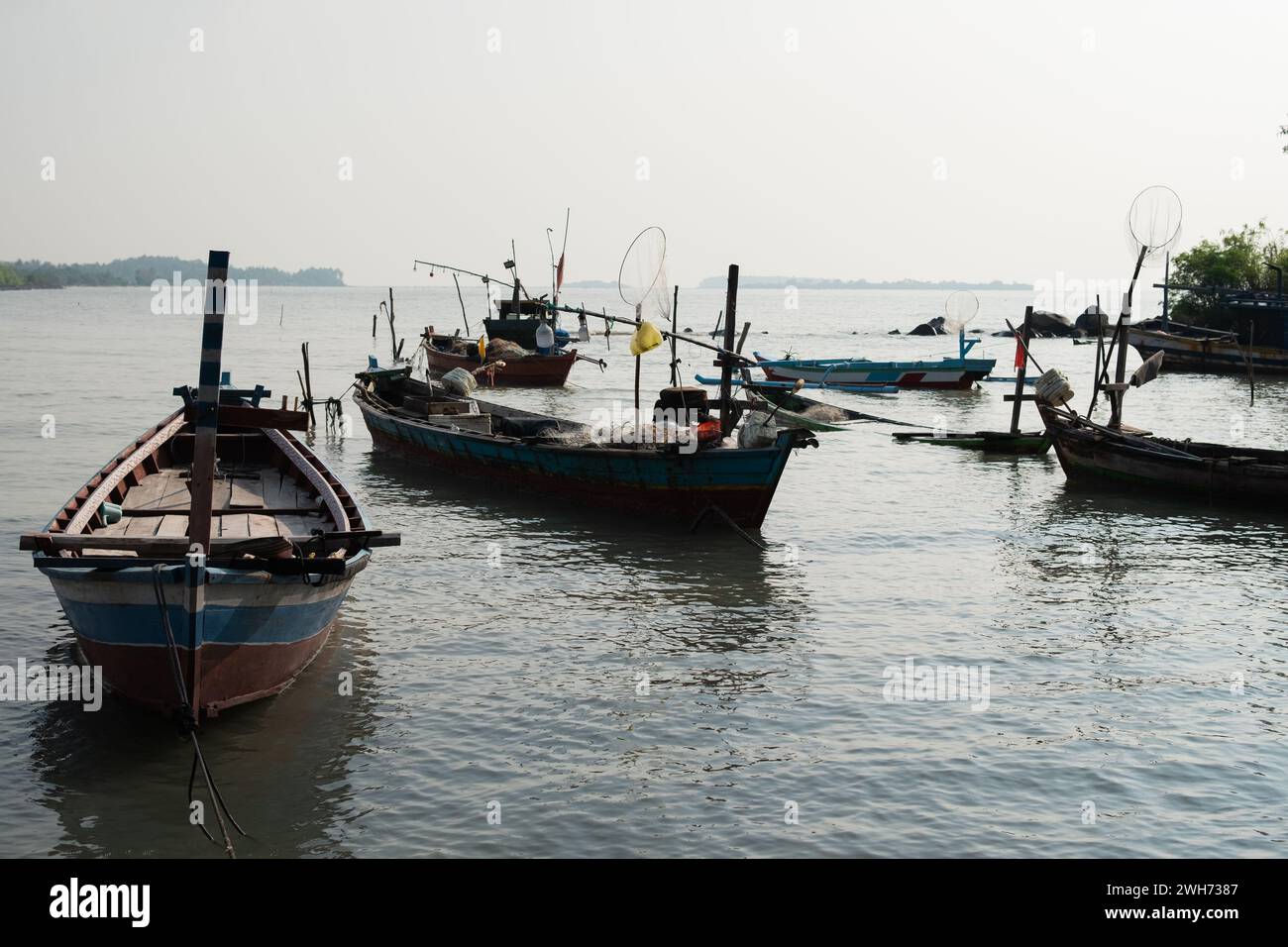 Fishing boats on the beach during morning fog on the water Stock Photo