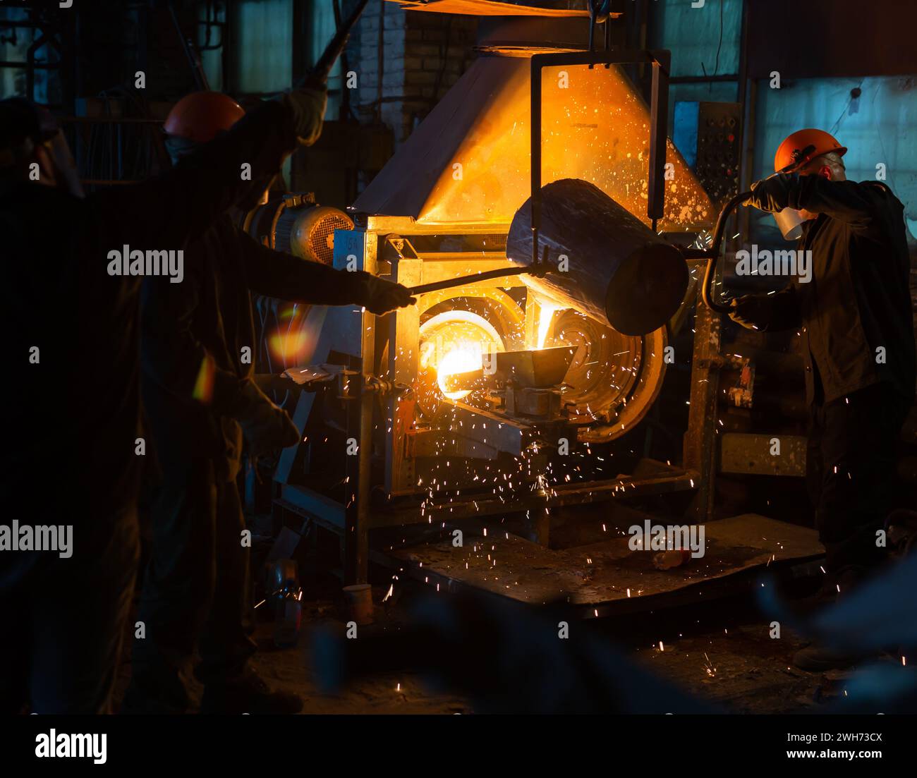Pouring molten metal into a centrifugal machine in the foundry shop of metallurgical plant Stock Photo
