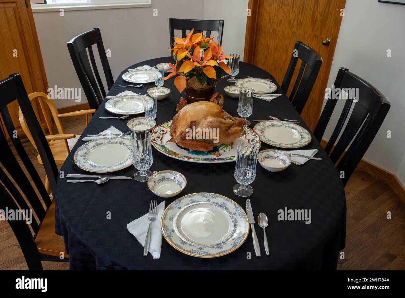 Table setting for a Thanksgiving holiday dinner with a roasted turkey