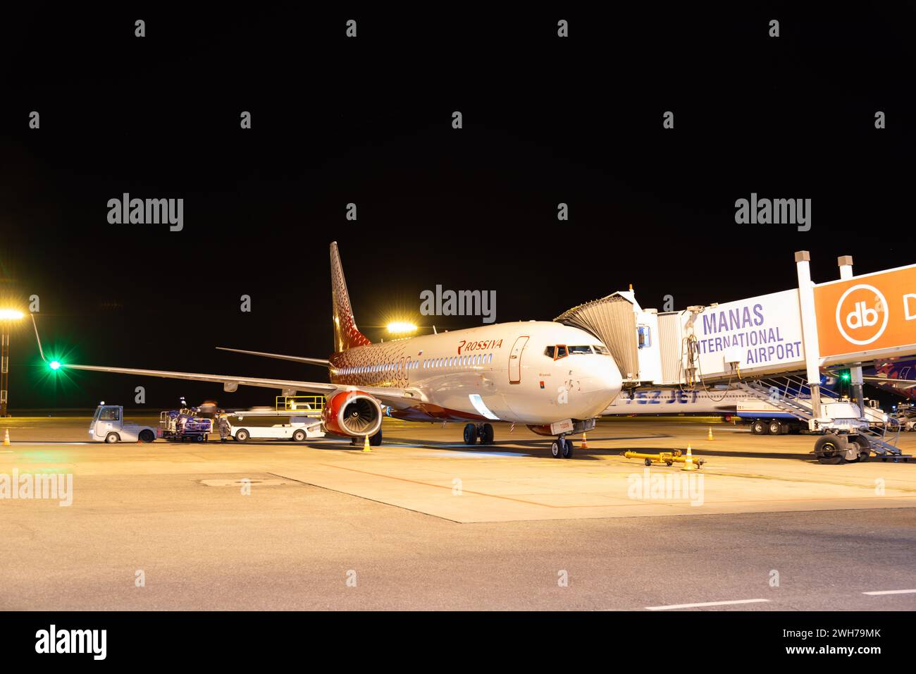 Bishkek, Kyrgyzstan - September 26, 2023: Rossiya Russian Airline plane with jetway at the Manas International Airport at night Stock Photo