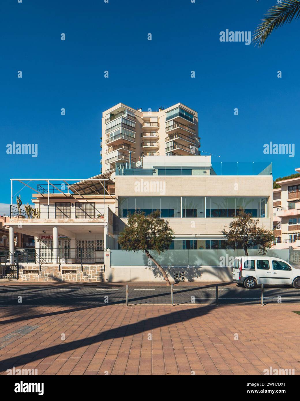 Exterior view of apartment building with parking lot and parked cars ...