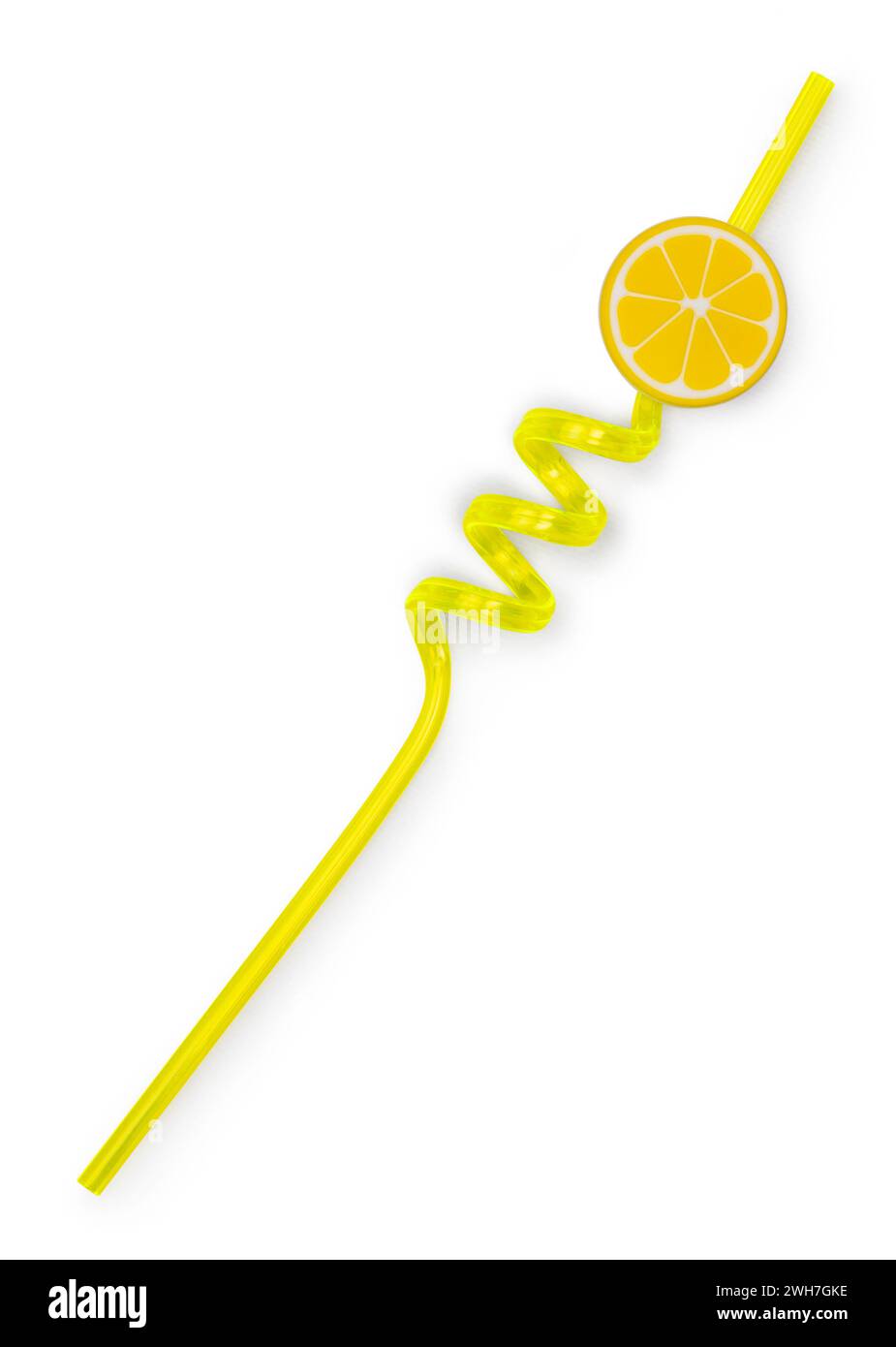 Yellow unused curly straw, top view. Isolated on a white background. Decorated with slice of lemon. Stock Photo