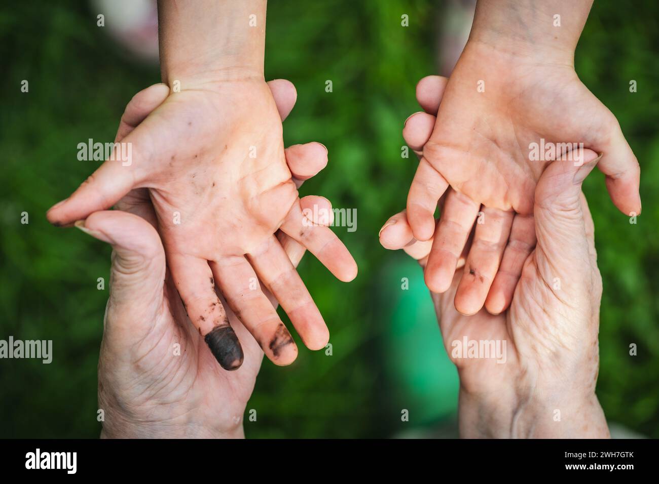 A little girl shows her filthy hands stained with black grease from playing outdoors which will