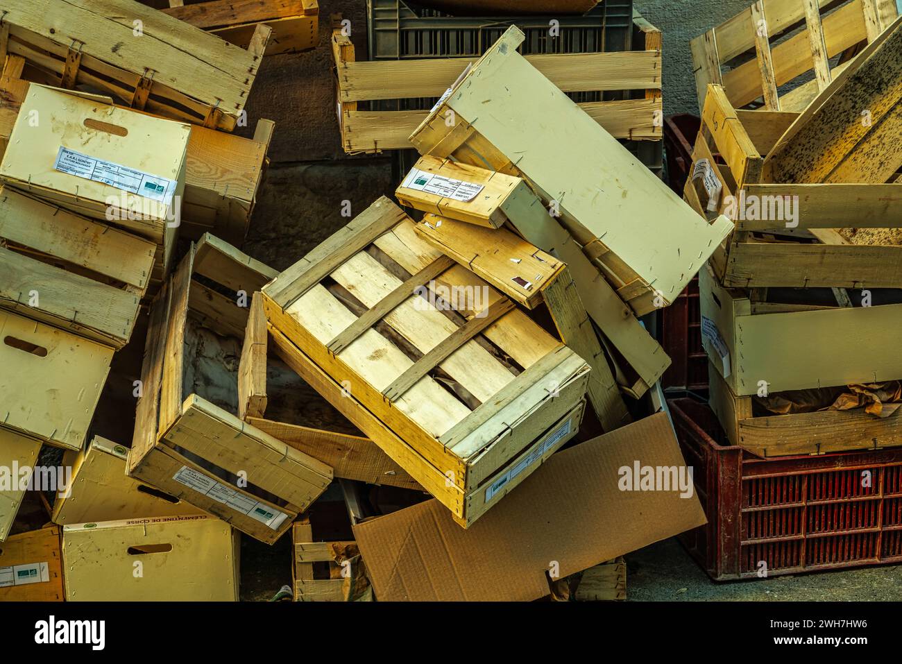 Wooden boxes used and then abandoned and piled up in a street corner. Italy Stock Photo