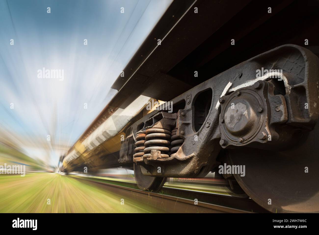 Freight train on the railroad. Industrial landscape of a freight train traveling on a railroad with blurred background. Stock Photo