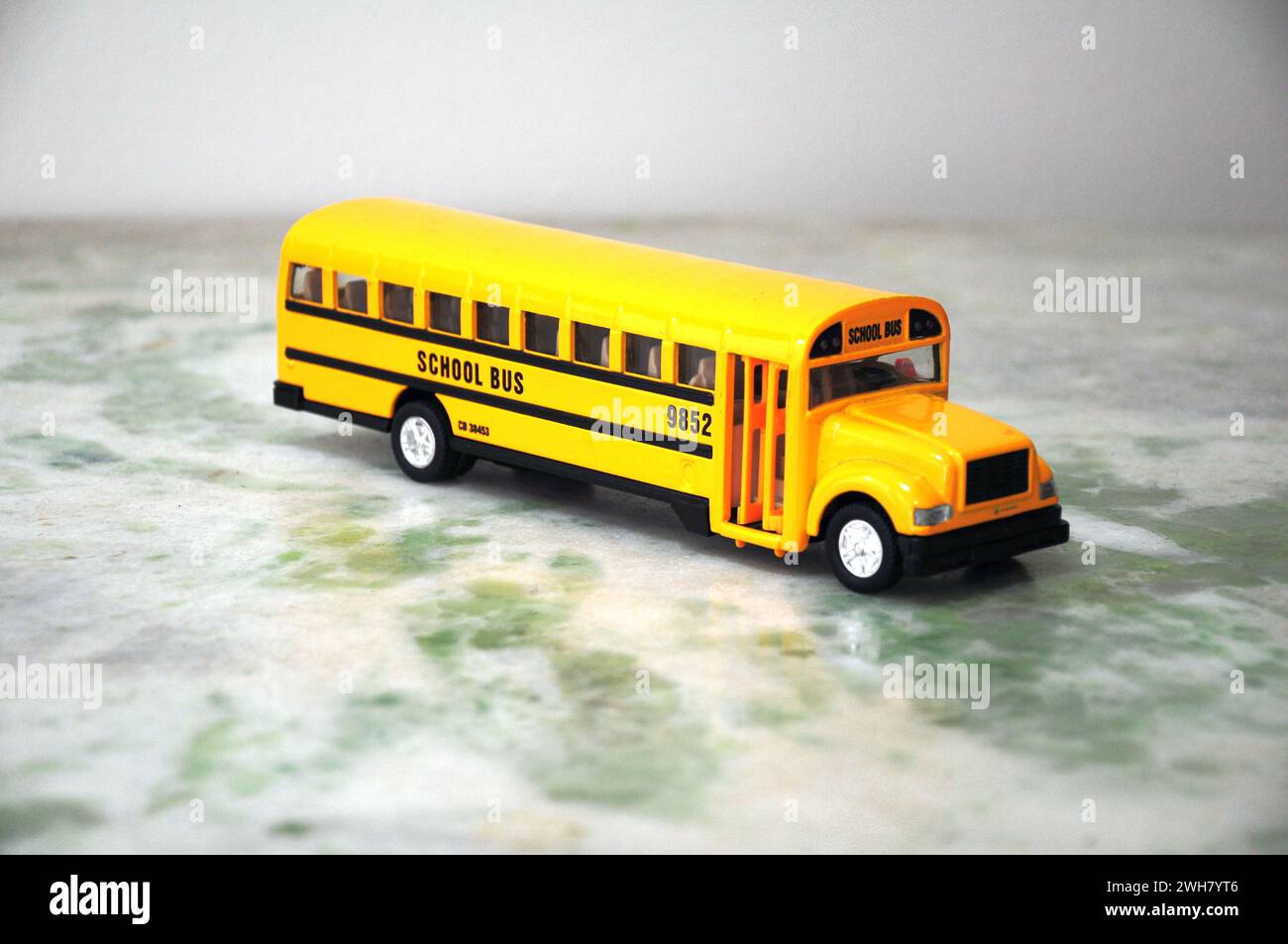American school bus miniature in standard yellow color with view of the entrance door Stock Photo