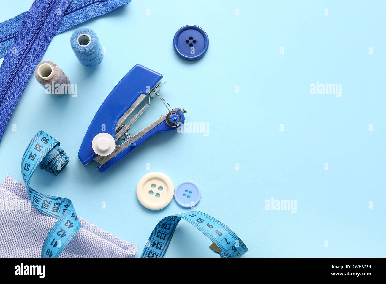 Manual sewing machine with different supplies on blue background Stock ...