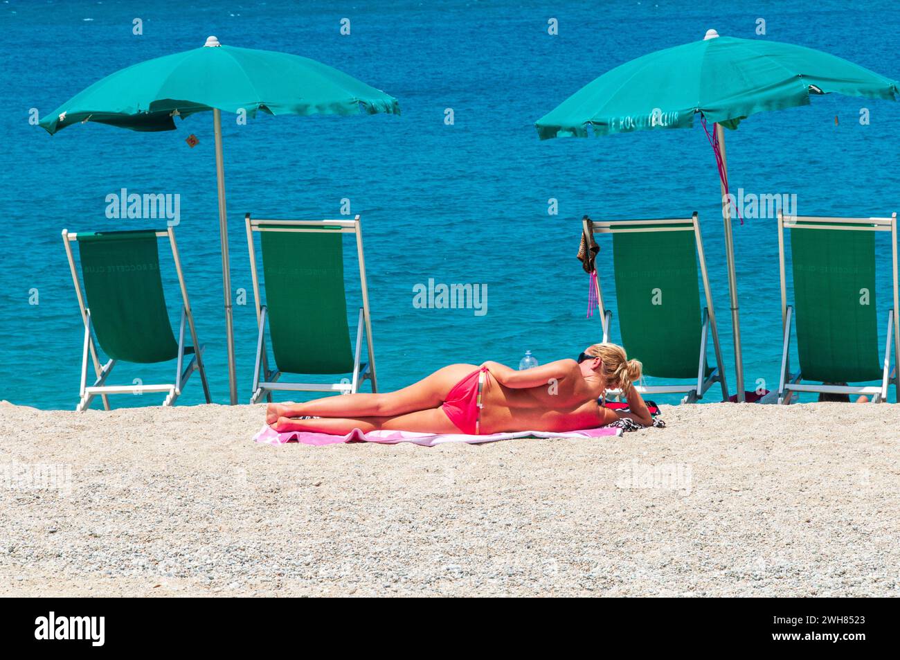 Eine Junge Frau beim sonnenbaden am Strand von Tropea Stock Photo