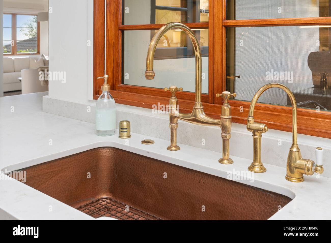 Large window behind copper sink in kitchen area Stock Photo