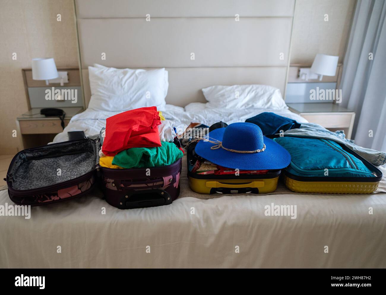 Suitcase with clothes on the bed. Preparing for vacation. Stock Photo