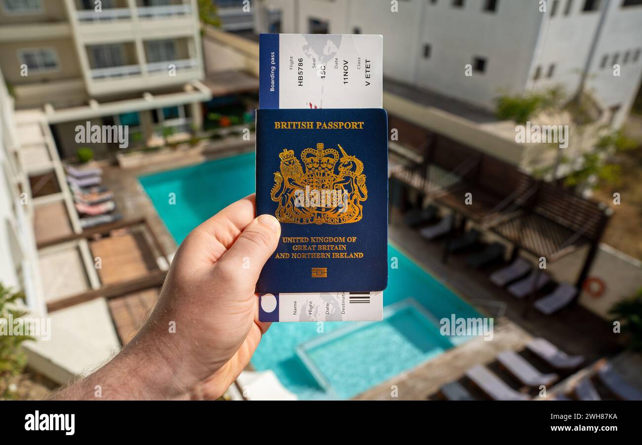 Man holding United Kingdom passport and airline ticket. Stock Photo