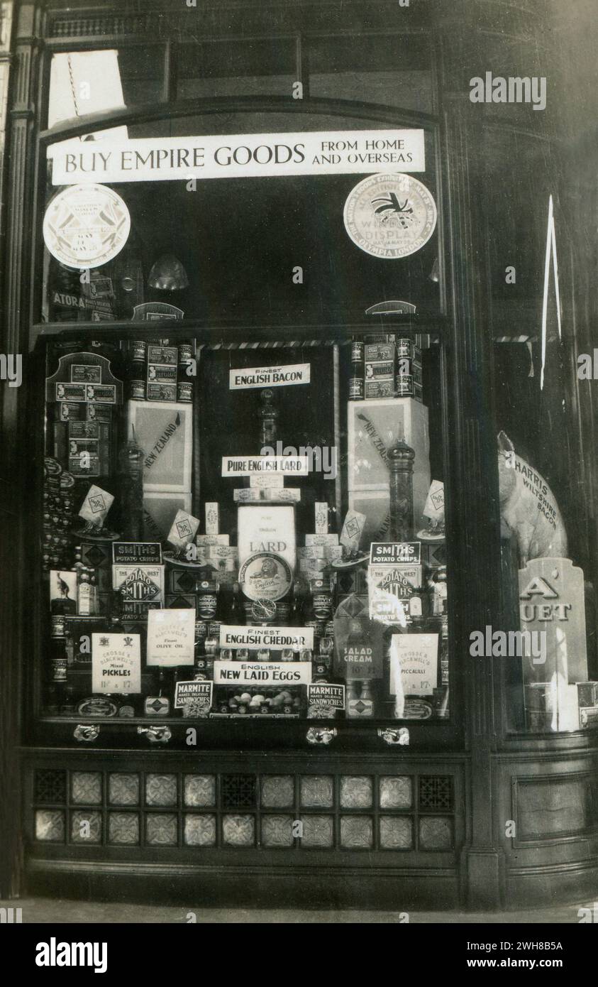 England. 1932 – A photograph depicting an interesting grocer’s shop window display, specially created for entry into the window display competition which was held between 14 – 28 May 1932 in connection with the Nation’s Food’s Exhibition at Olympia Exhibition Centre, London, 21 May – 4 June 1932. The display includes a wide range of produce, artistically arranged. At the top of the window is a sign with the slogan, “Buy Empire Goods From Home and Overseas”. Stock Photo