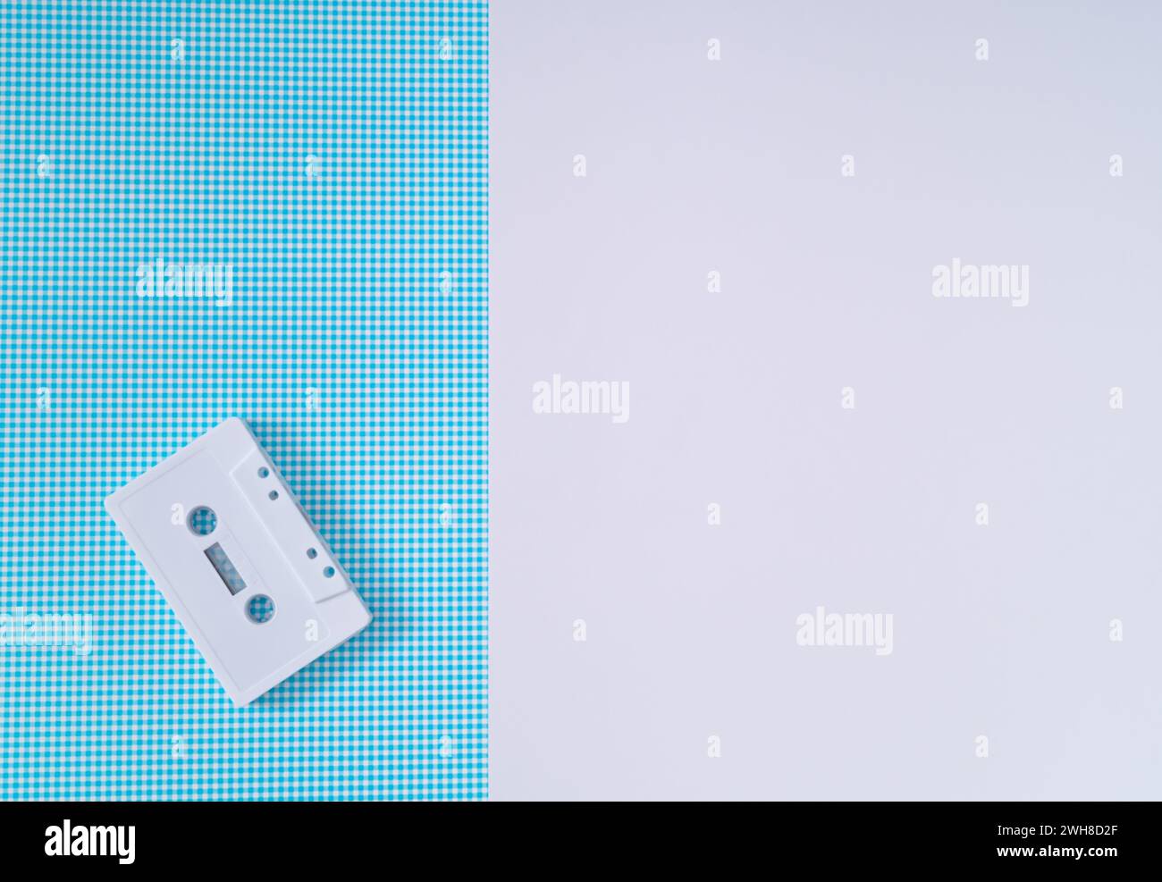 Layout of retro white audio cassette tape on white and blue background. Creative concept of old technology. 80's aesthetic. Vintage audio cassette Stock Photo