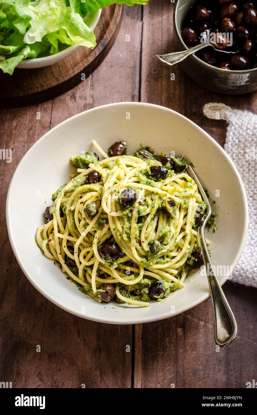 Spaghetti with escarole pesto and black olives Stock Photo