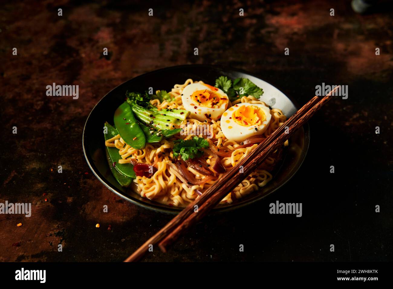 Egg and Vegetable Noodles in bowl with chopsticks Stock Photo