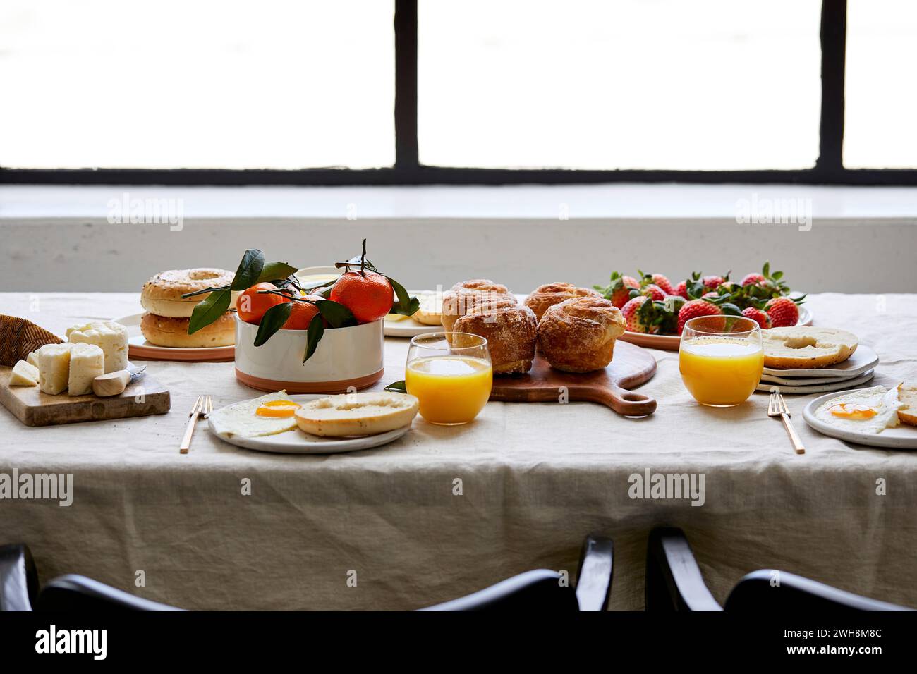 Breakfast Tablescape with Pastries, Orange Juice and Fruit Stock Photo