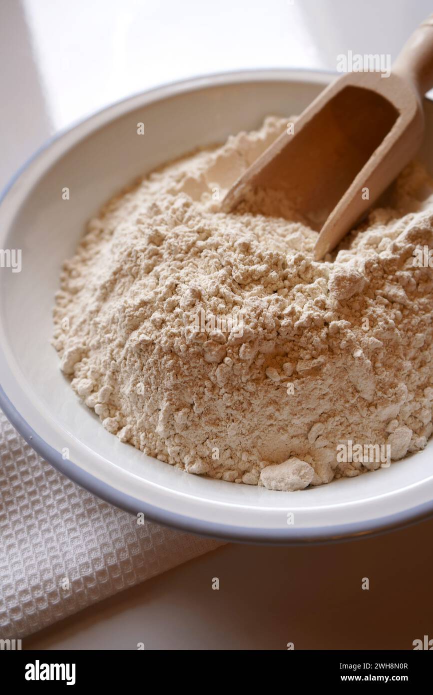 Buckwheat flour cooking and baking ingredient in white enamel bowl, closeup. Stock Photo