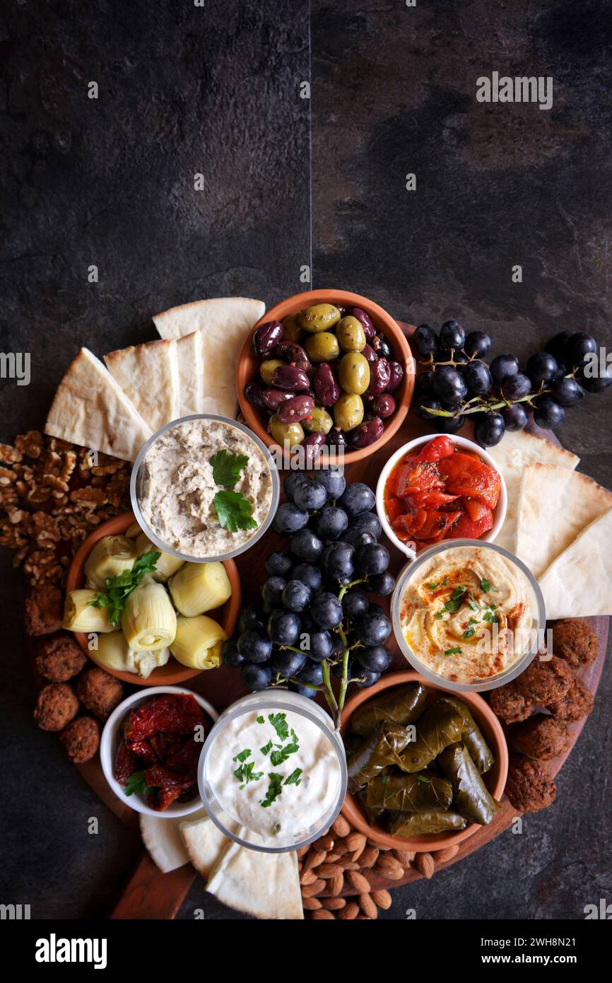 Mediterranean diet charcuterie board grazing platter on dark slate background, with negative copy space. Stock Photo