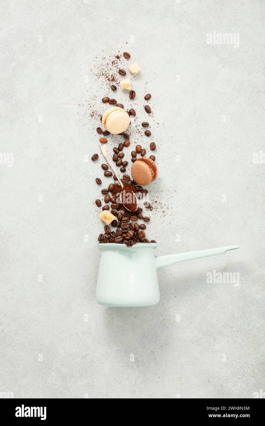 Coffee turk and flying coffee beans and macarons on concrete background flat lay Stock Photo