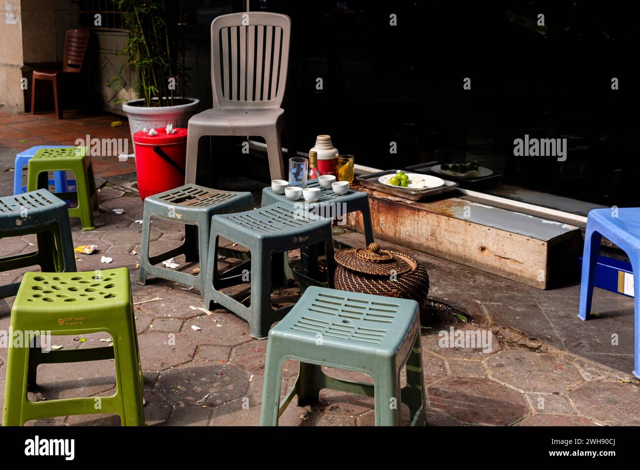 Several empty plastic stools and debris after a meal in a typical Hanoi street scene Stock Photo