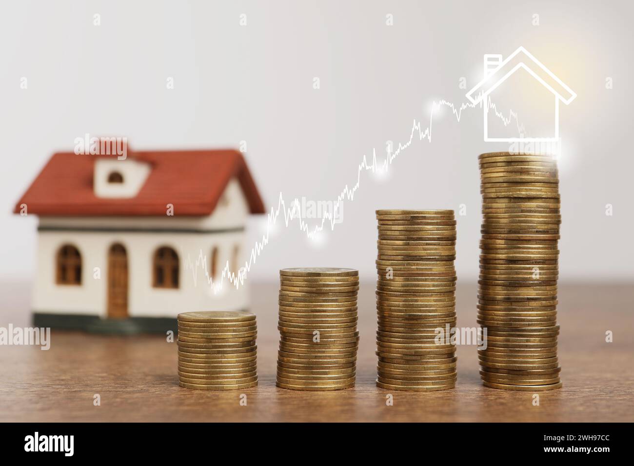 Mortgage rate. Stacked coins, graph and model of house Stock Photo - Alamy